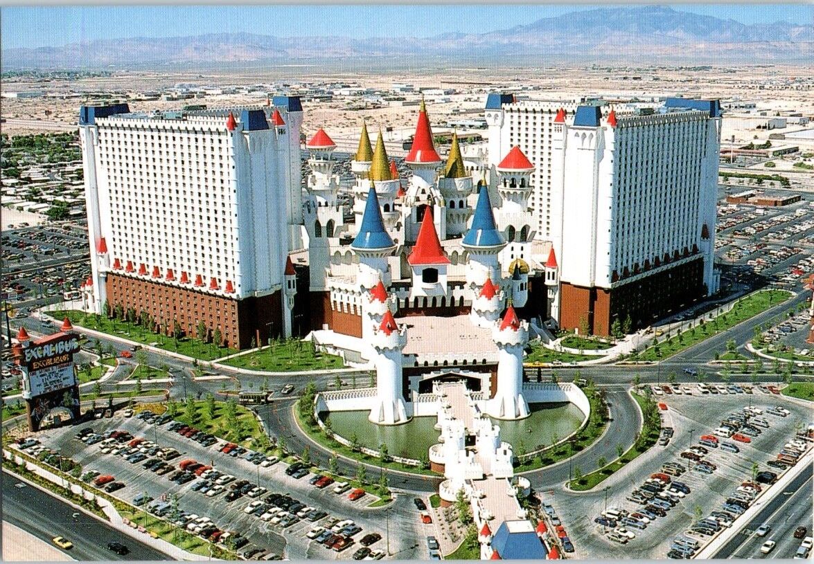 a large white building with multi-colored towers with Excalibur Hotel and Casino in the background