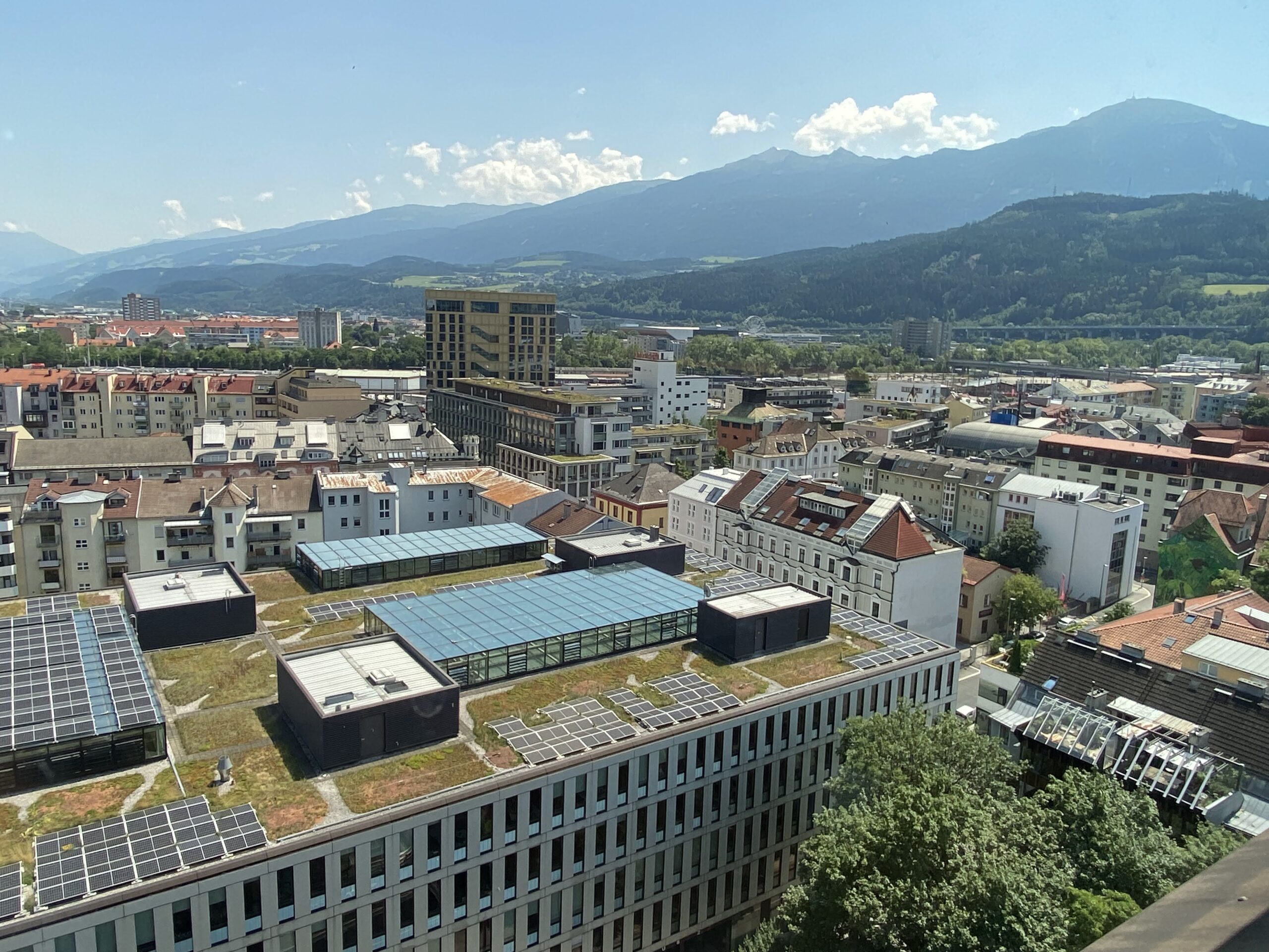 a city with many buildings and mountains in the background