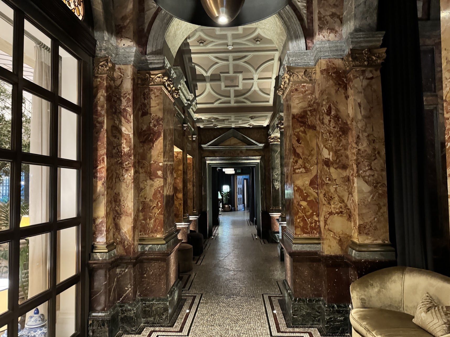 a hallway with marble columns and a tile floor