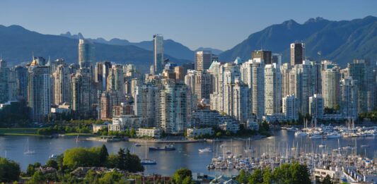 a city with many tall buildings and boats on water