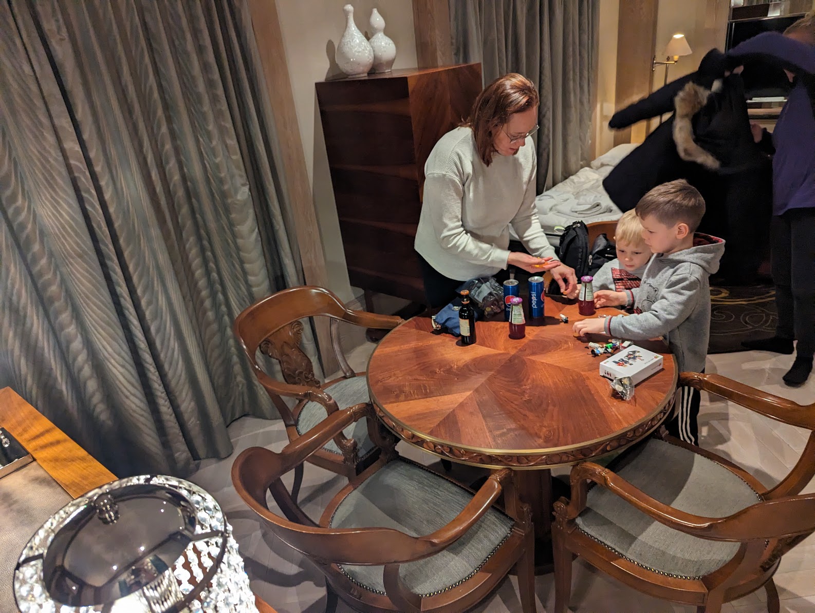 a woman and two kids playing cards at a table